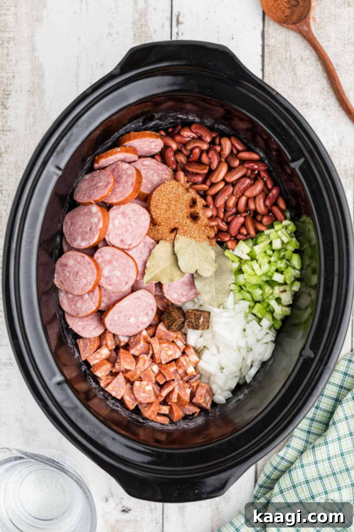 Soulful Slow Cooker Cajun Red Beans and Rice 4 AN overhead image of a crock pot filled with ingredients needed to make a Cajun red beans and rice recipe.