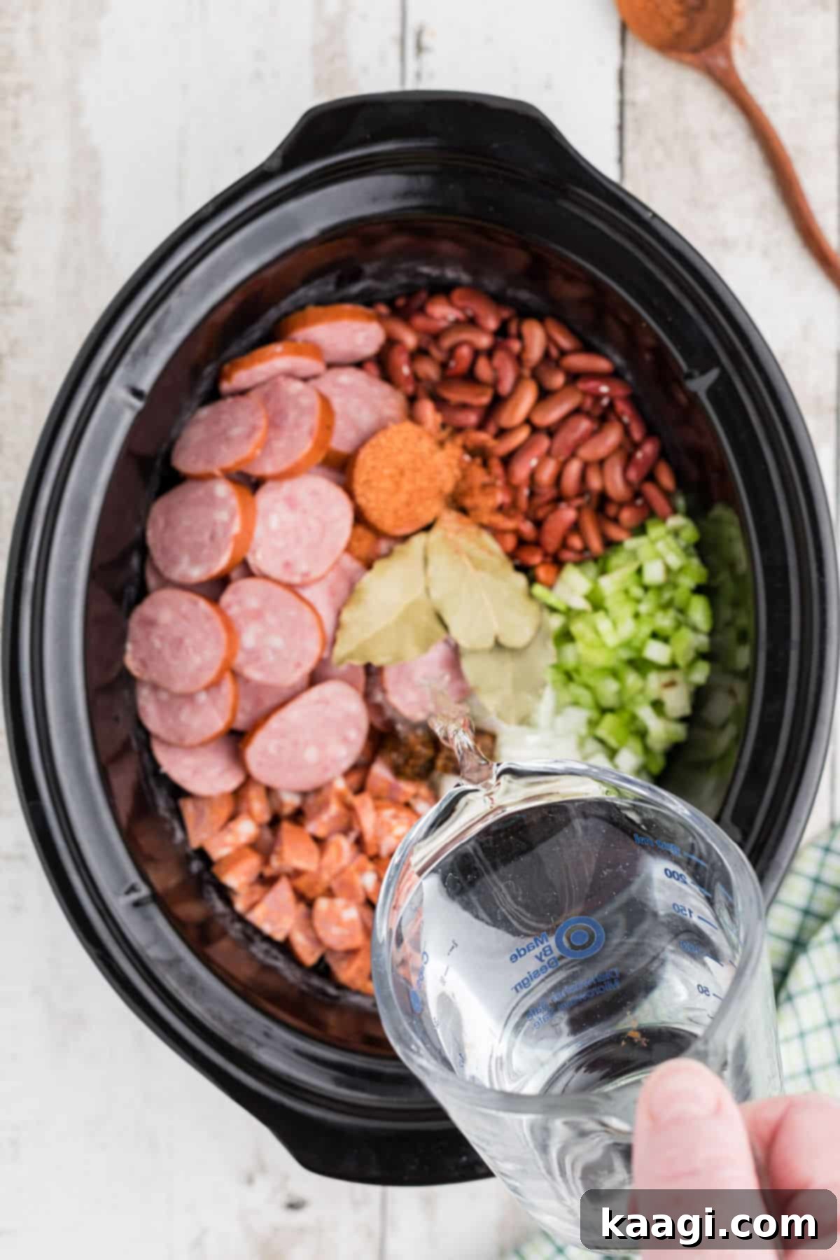 Soulful Slow Cooker Cajun Red Beans and Rice 5 A slow cooker cajun red beans and rice recipe with water being poured in.