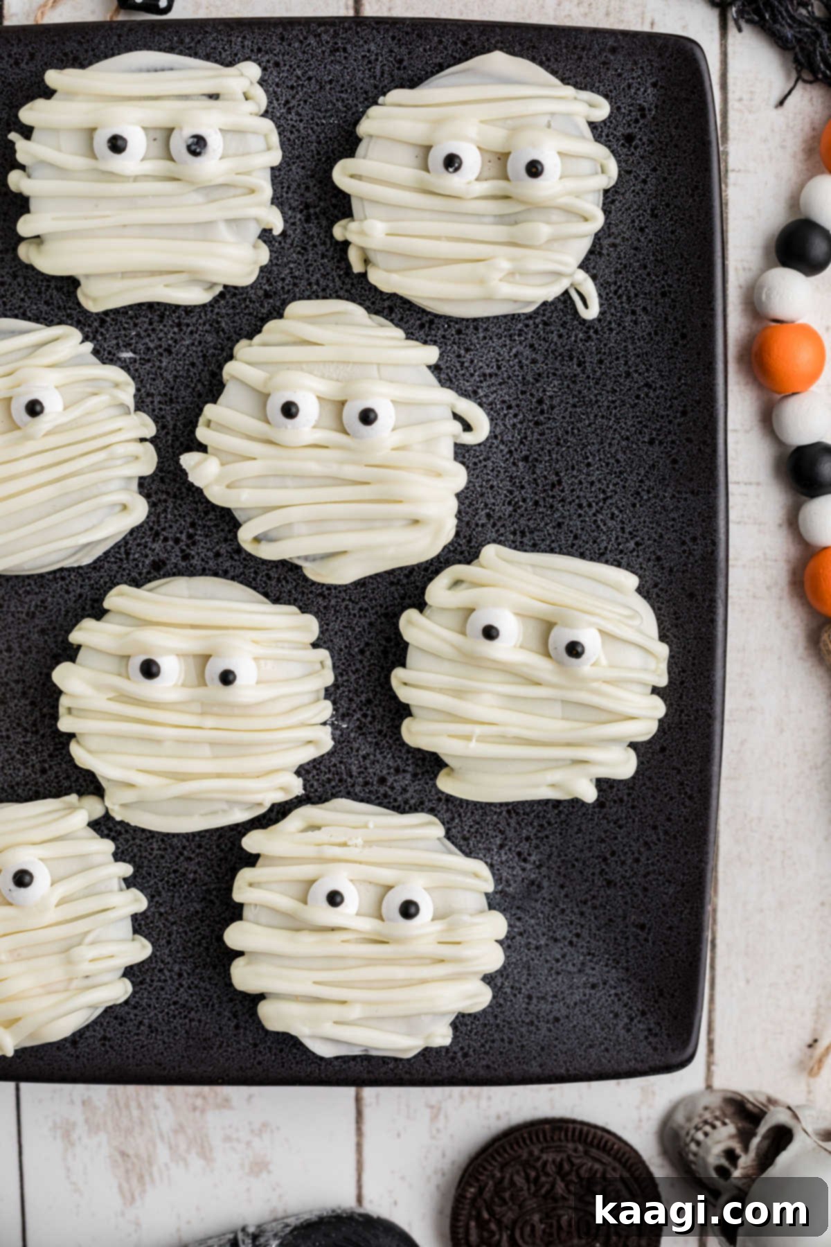 Mummy Oreos on a square black plate, showcasing their eerie charm for Halloween.
