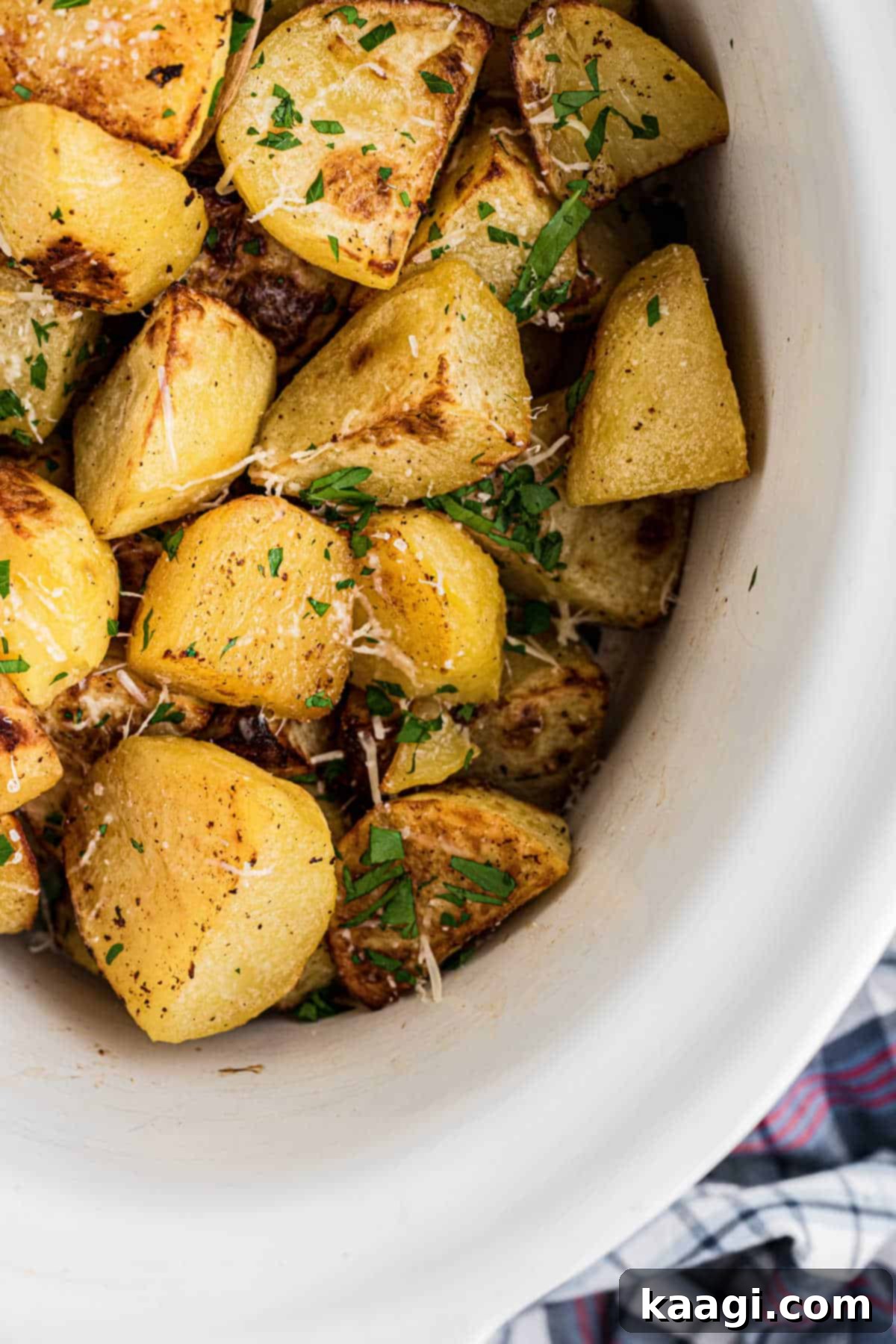 Perfectly Tender Slow Cooker Roast Potatoes 6 Close up of a slow cooker roast potatoes recipe, from the corner, showcasing the crisp edges and seasonings.