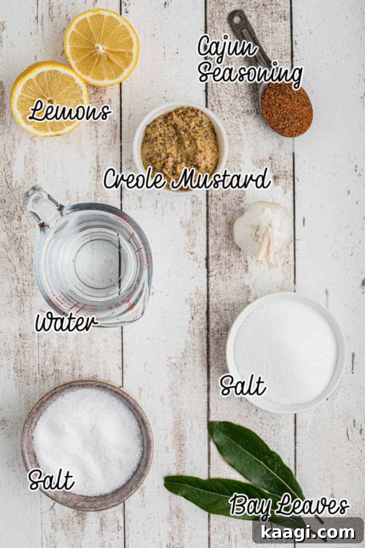 Assortment of ingredients including salt, sugar, lemons, garlic, bay leaves, and Creole mustard, laid out on a table for a Cajun Turkey Brine.
