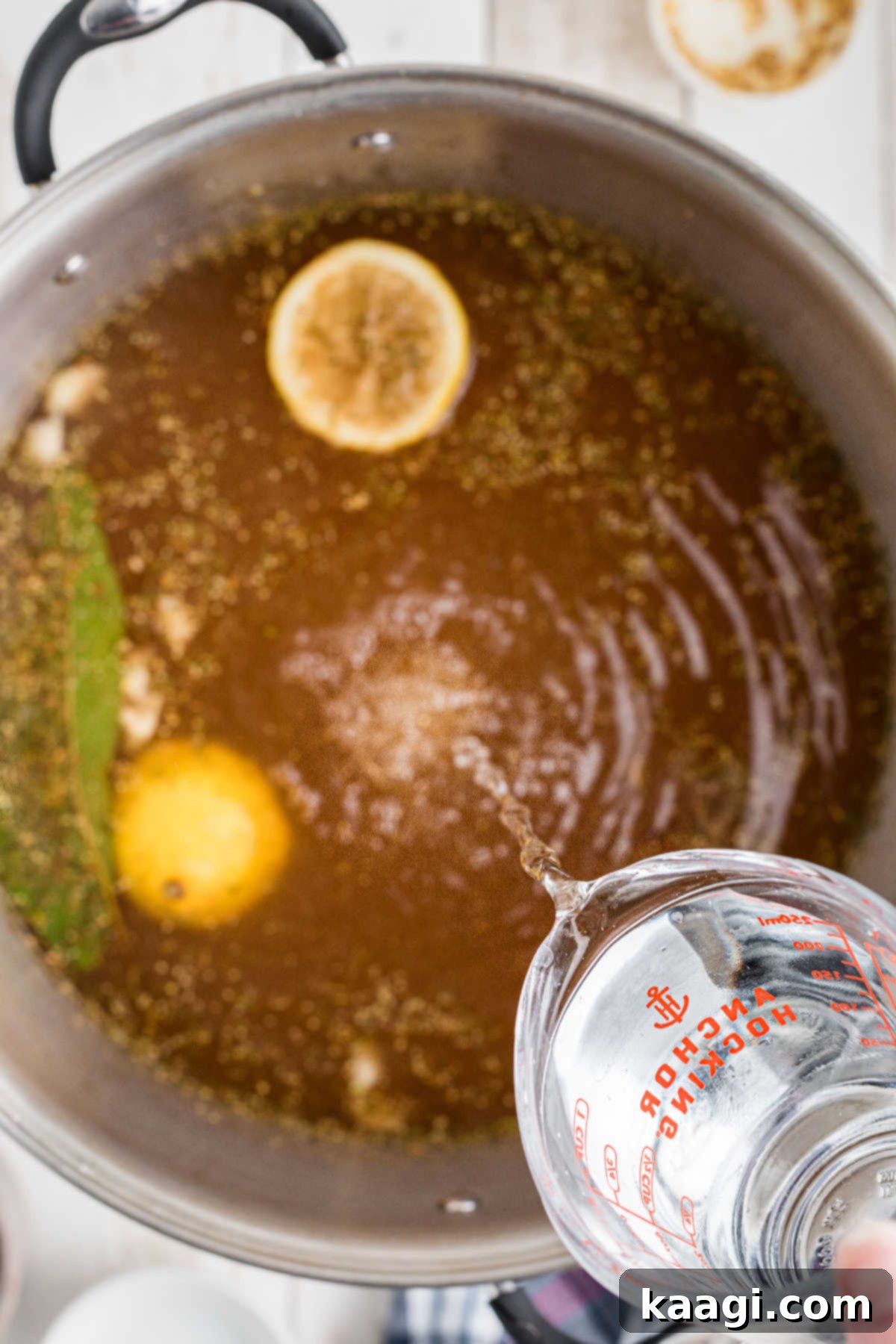 Additional cold water being poured into the stock pot to cool the brine mixture.