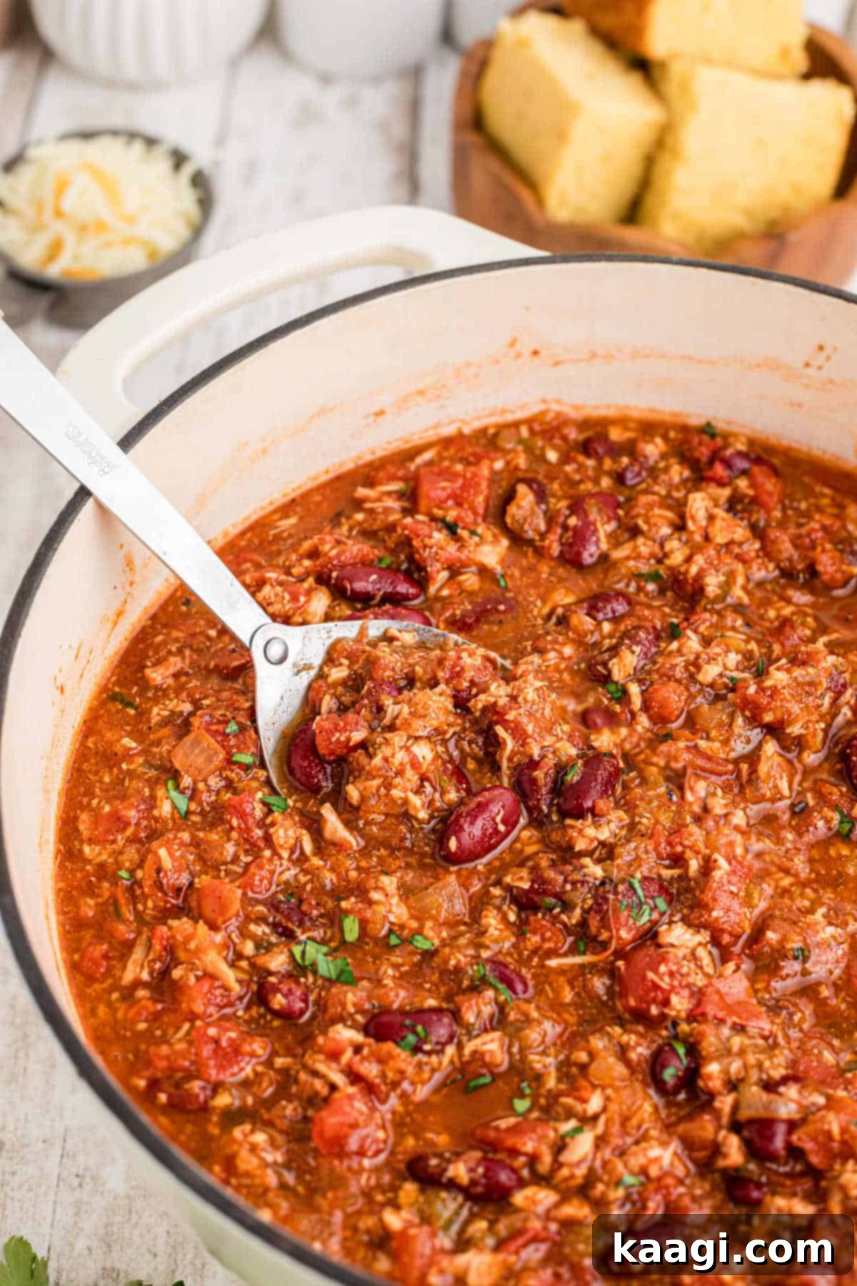 Rich and Hearty Dutch Oven Turkey Chili 9 Close up shot of a Dutch Oven turkey chili with a spoon dipping in.