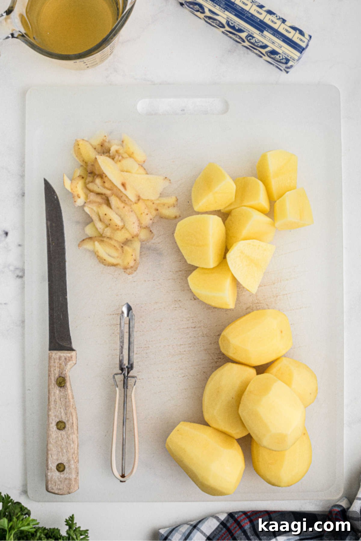 Savory Slow Cooker Mashed Potatoes 4 Potatoes being peeled and chopped.