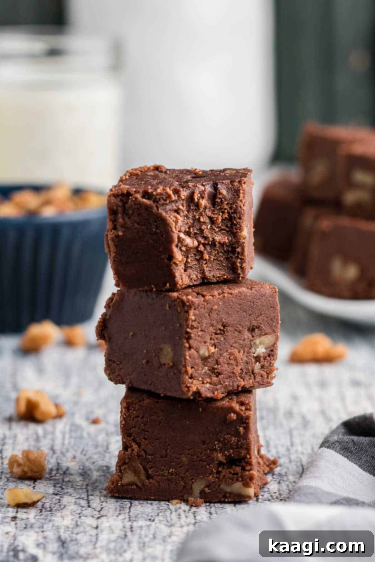 A delectable pile of three glossy, rich chocolate Amish Fudge pieces, ready to be enjoyed.