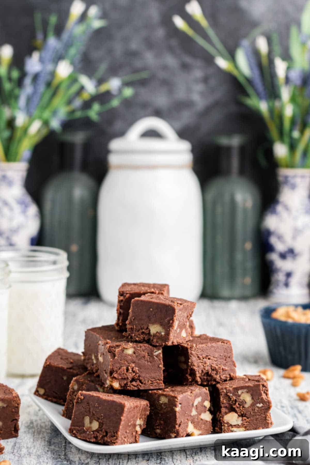 A beautifully presented plate overflowing with squares of rich, homemade Amish fudge, showcasing its perfect texture.