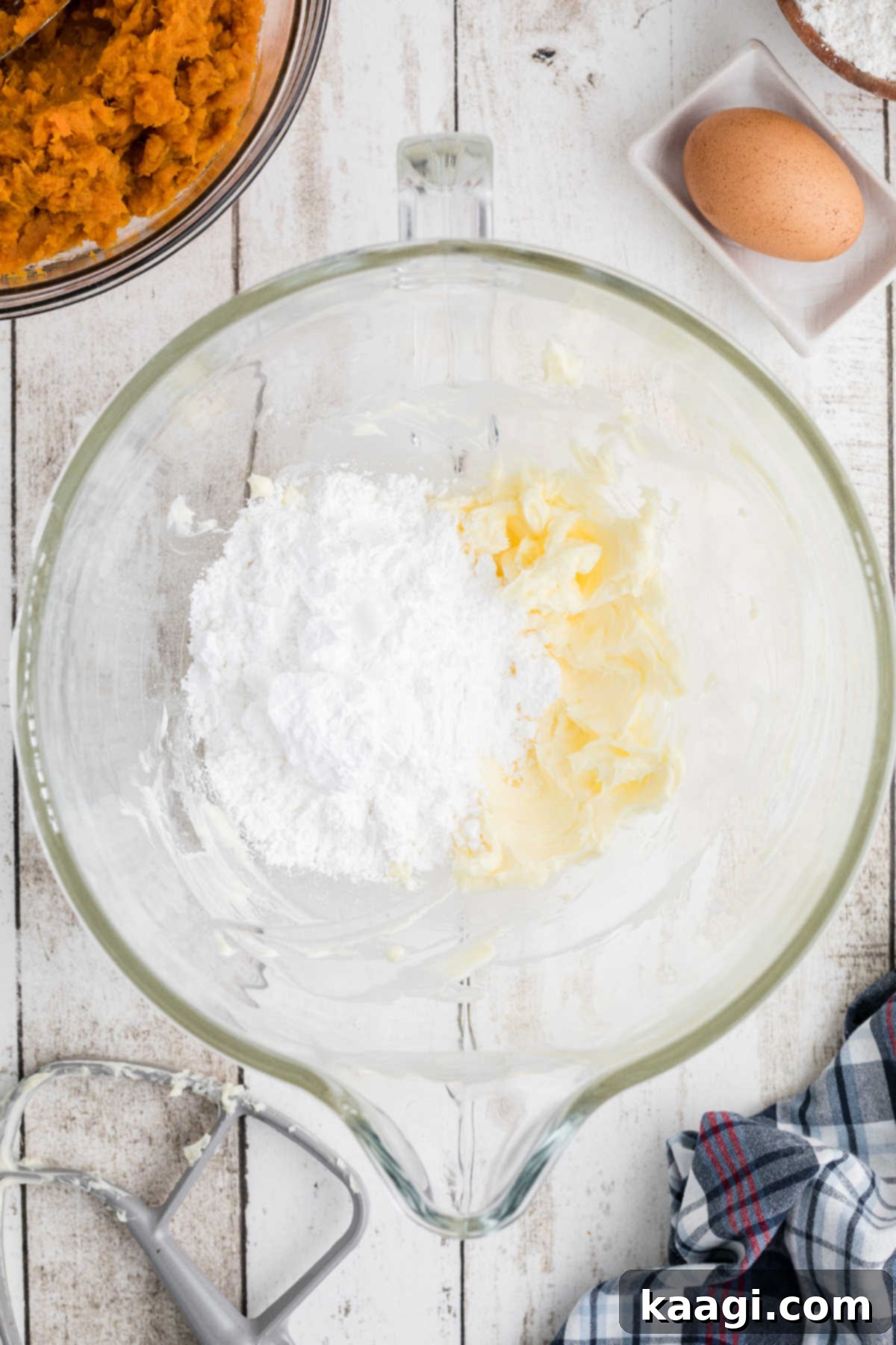 Powdered sugar added to a mixing bowl with butter.