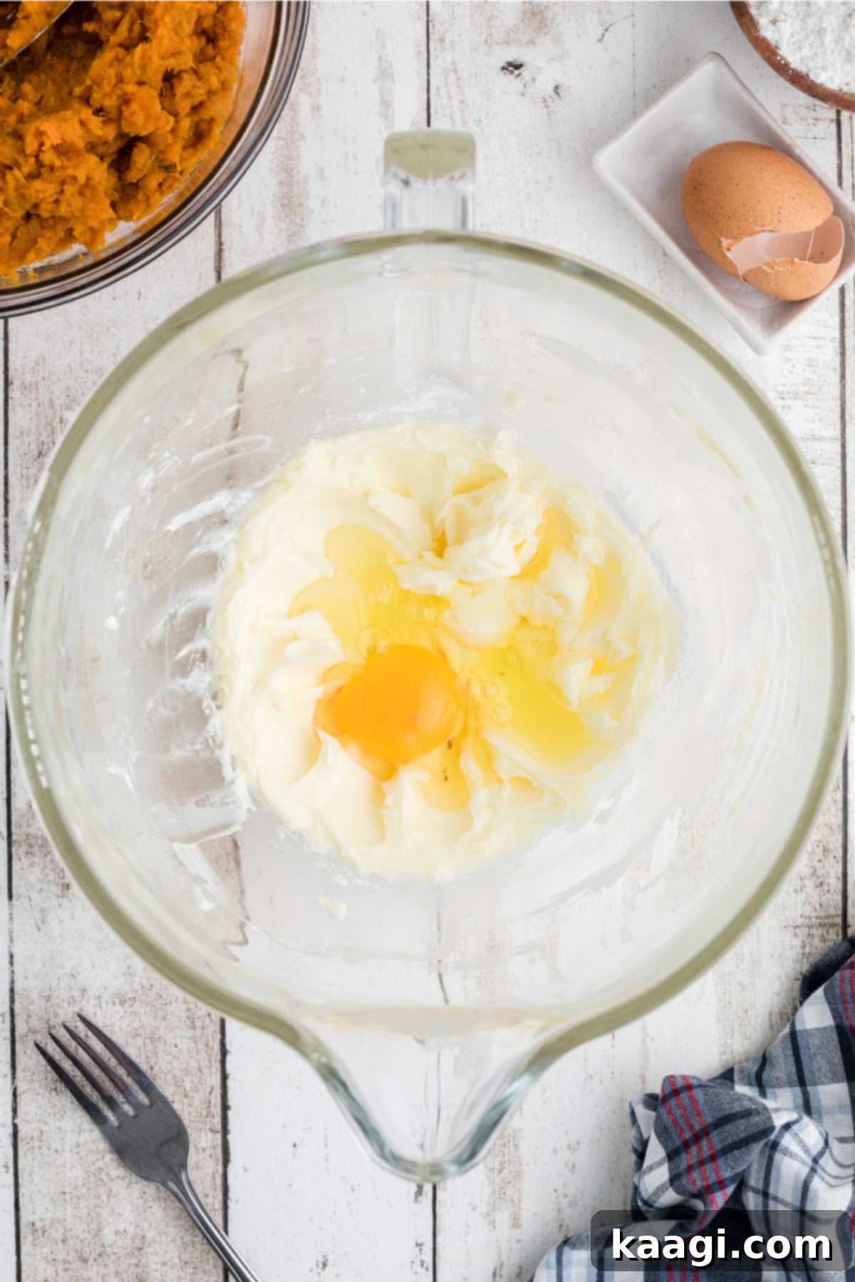 Eggs added to a mixing bowl.