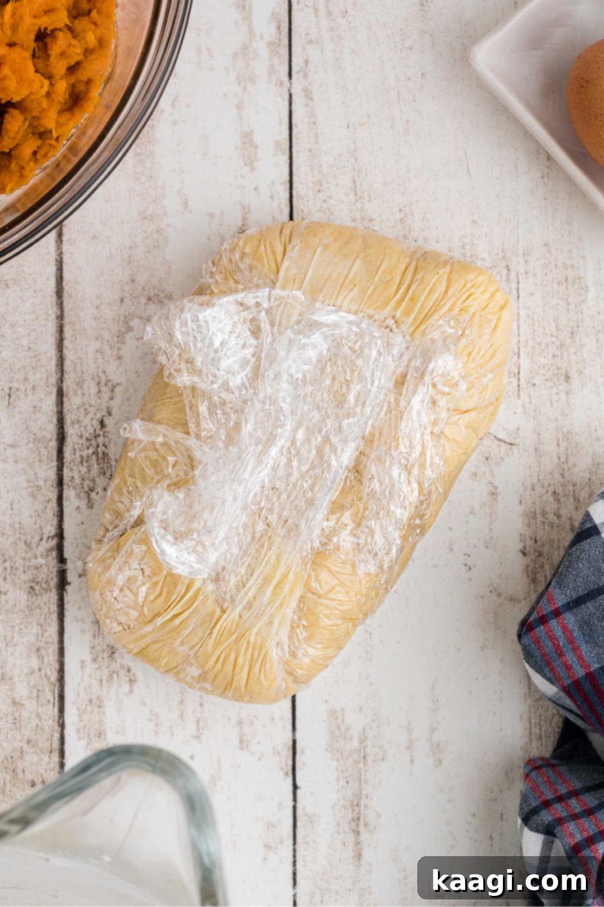 Pie dough wrapped in plastic wrap.