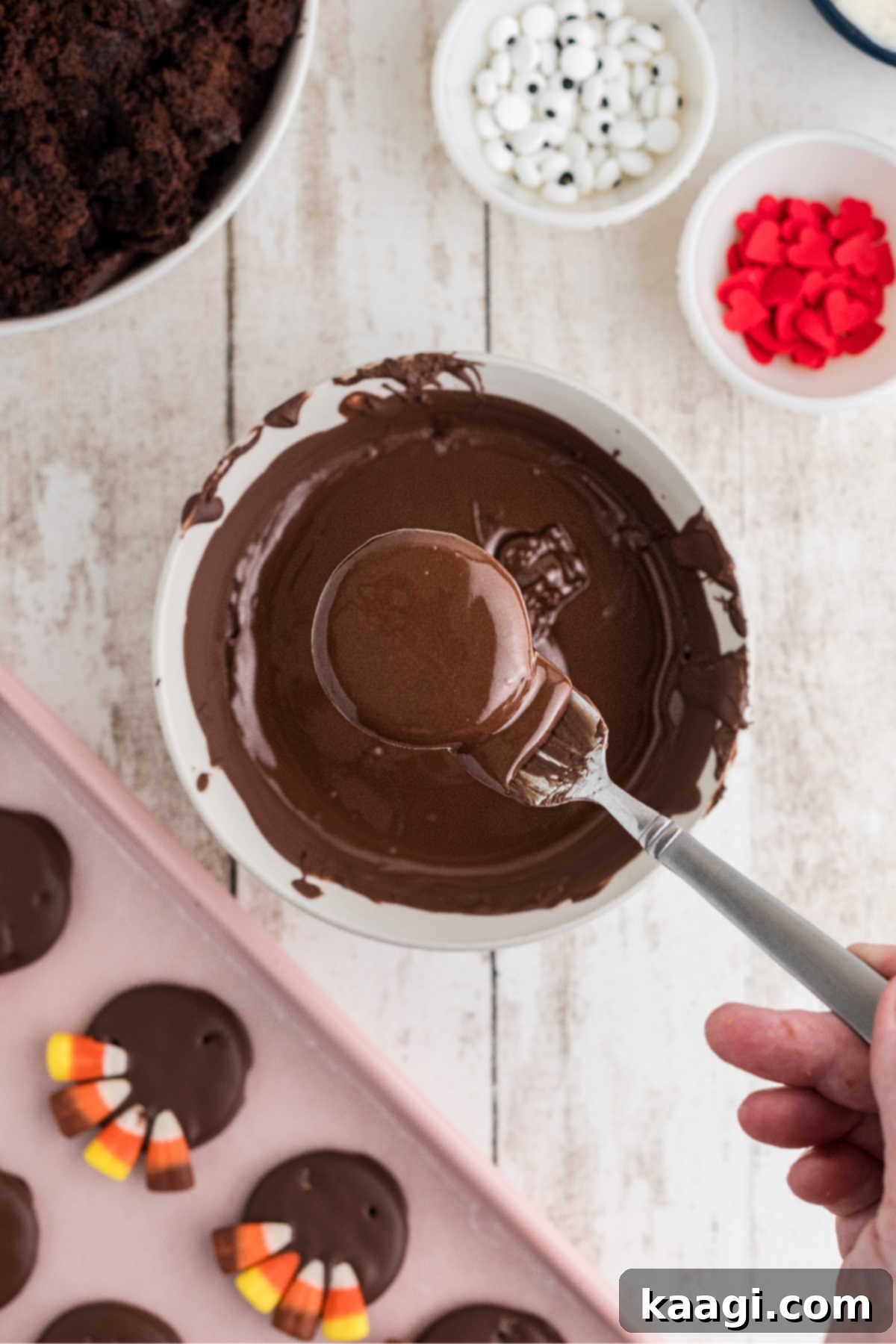 Festive Thanksgiving Cake Pops 4 A Ritz cracker being dipped into rich, melted chocolate almond bark, getting fully coated.