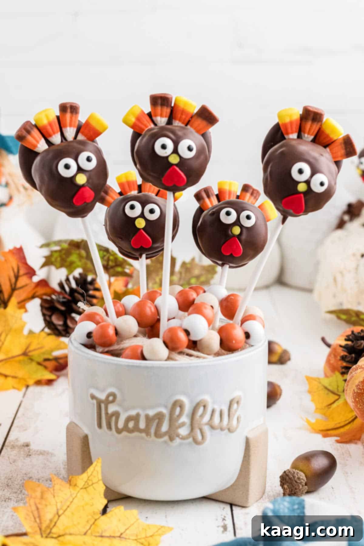 Festive Thanksgiving Cake Pops 8 A beautiful arrangement of finished Thanksgiving cake pops, elegantly displayed in a decorative 'Thankful' vase.