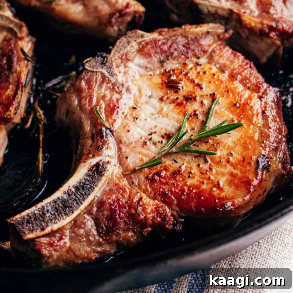 Southern Skillet Classics 10 Thick-cut cast iron pork chops, seared to a beautiful golden crust and resting with fresh rosemary.