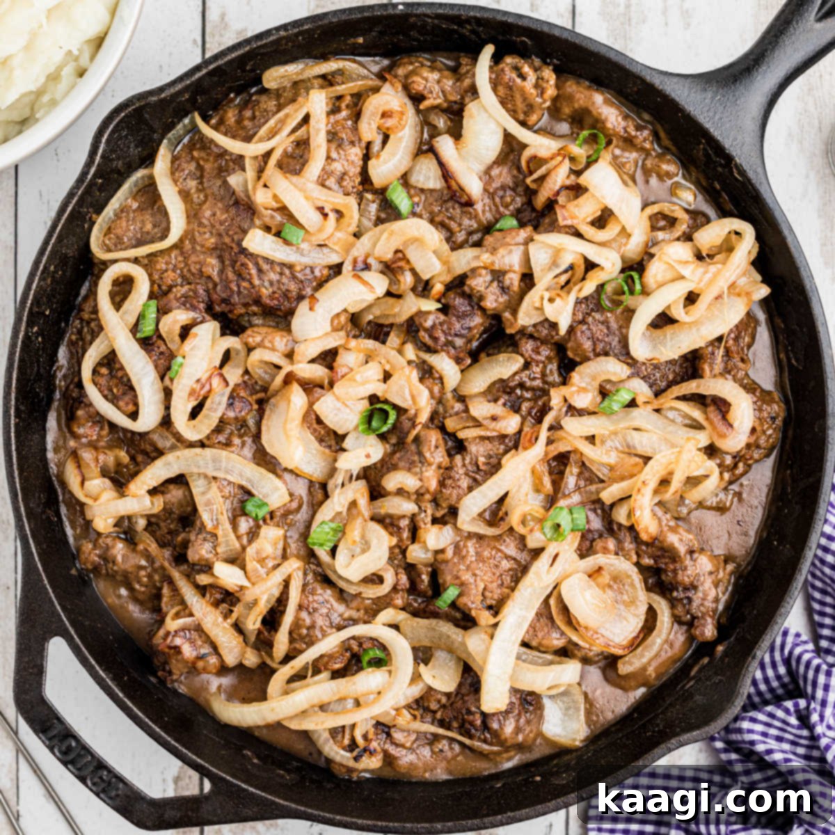 Southern Skillet Classics 5 A cast iron pan full of perfectly cooked liver and onions, generously covered in a rich brown gravy.