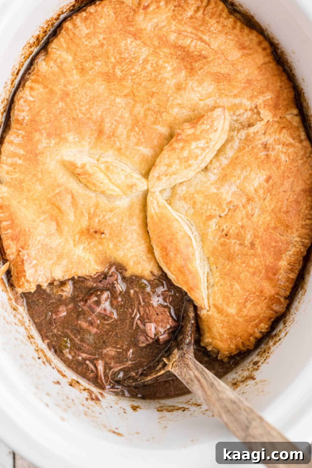 Overhead shot of a slow cooker steak pie recipe with a spoon sitting in it.