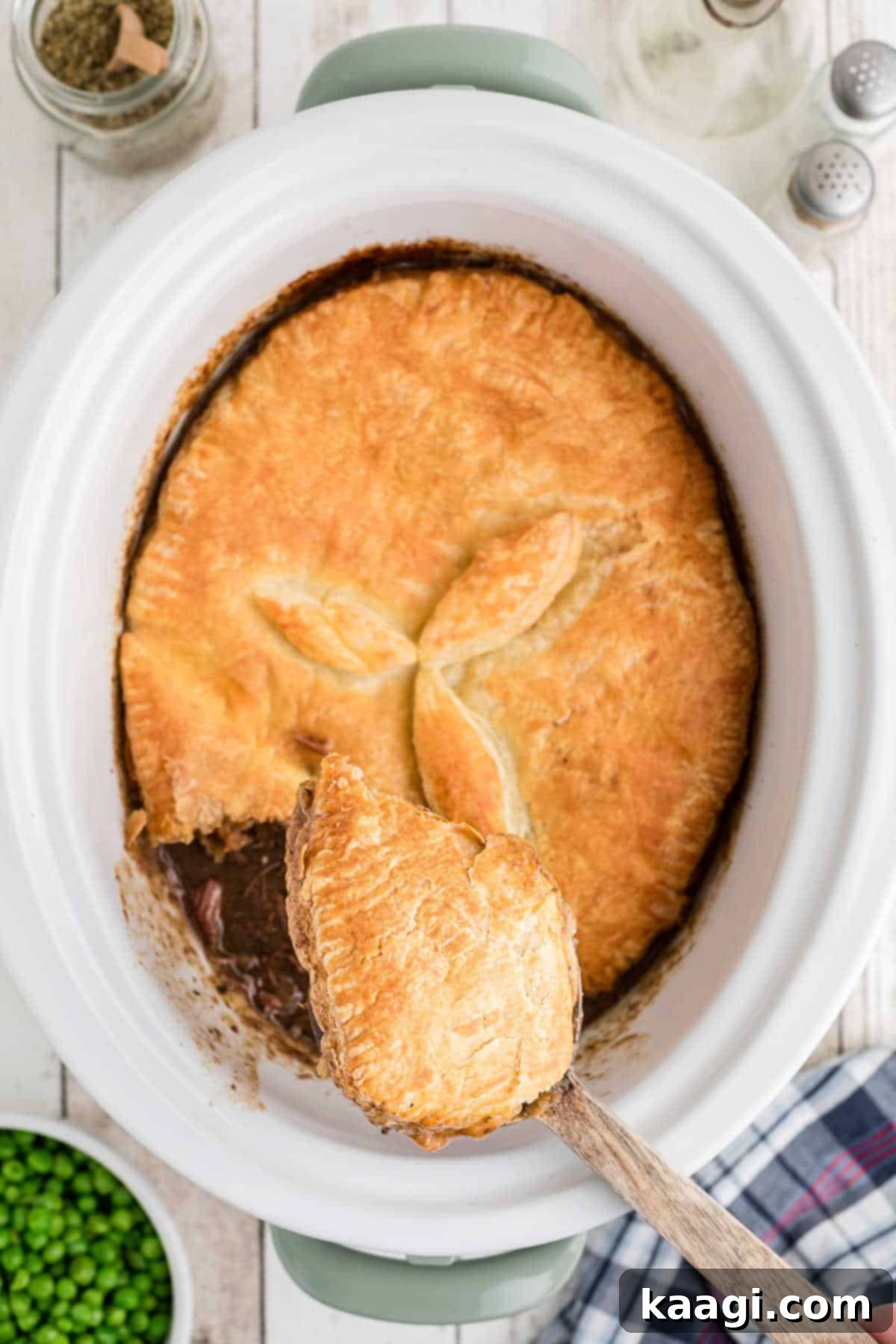 Overhead view of a spoon lifting out some slow cooker steak pie.