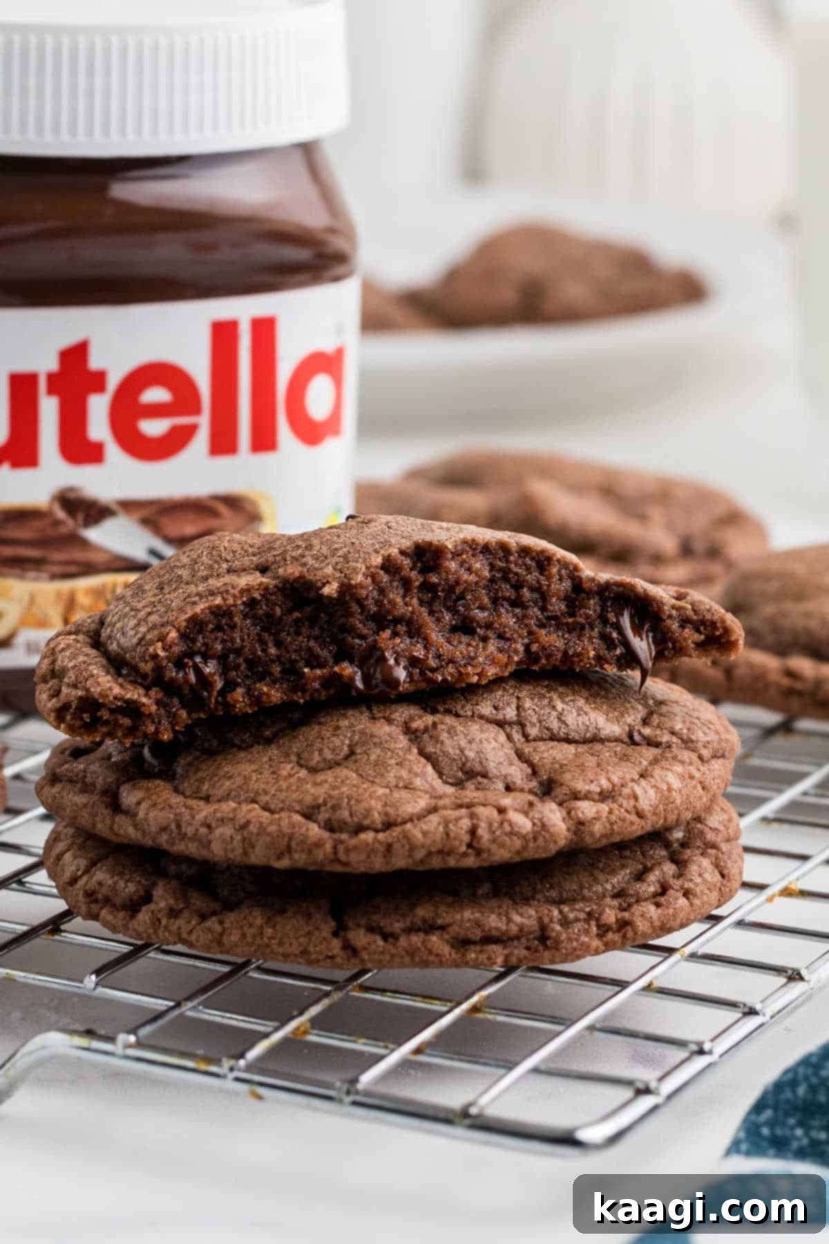 Close up of some Nutella Brownie Cookies on a wire rack, showcasing their fudgy texture and chocolate chips.