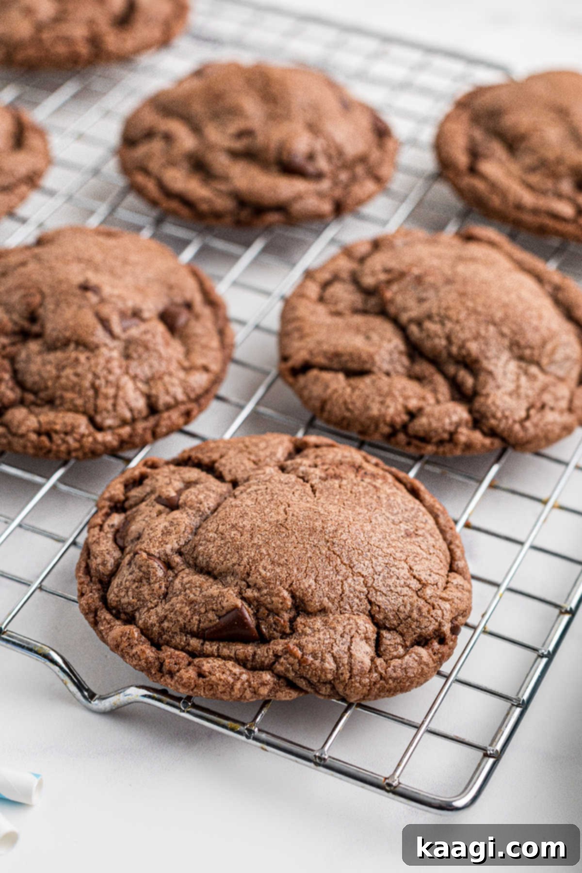 Warm Nutella cookies cooling on a wire rack after being transferred from the baking sheet.
