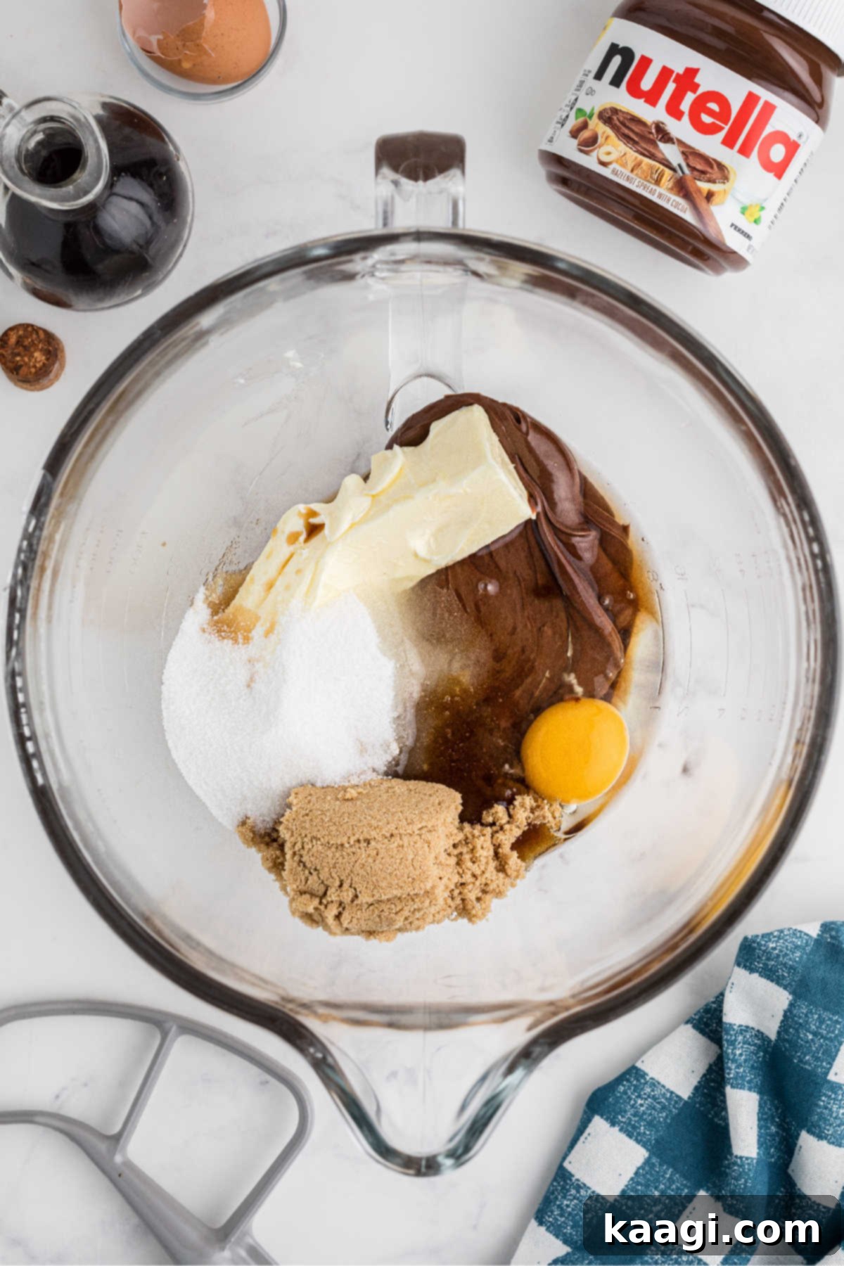 Eggs, Nutella, butter, and sugars in a mixing bowl, ready to be creamed together.
