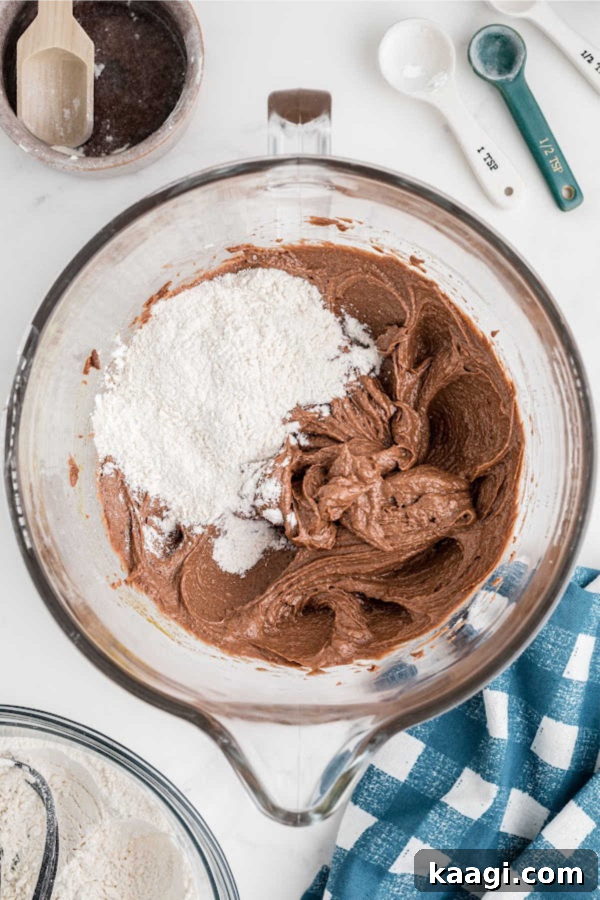 Dry ingredients being gradually added to the wet ingredients in a stand mixer.