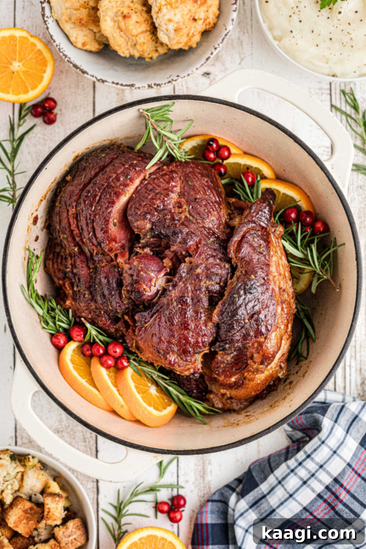 A beautifully baked ham, golden brown and glistening, inside a Dutch oven after cooking.