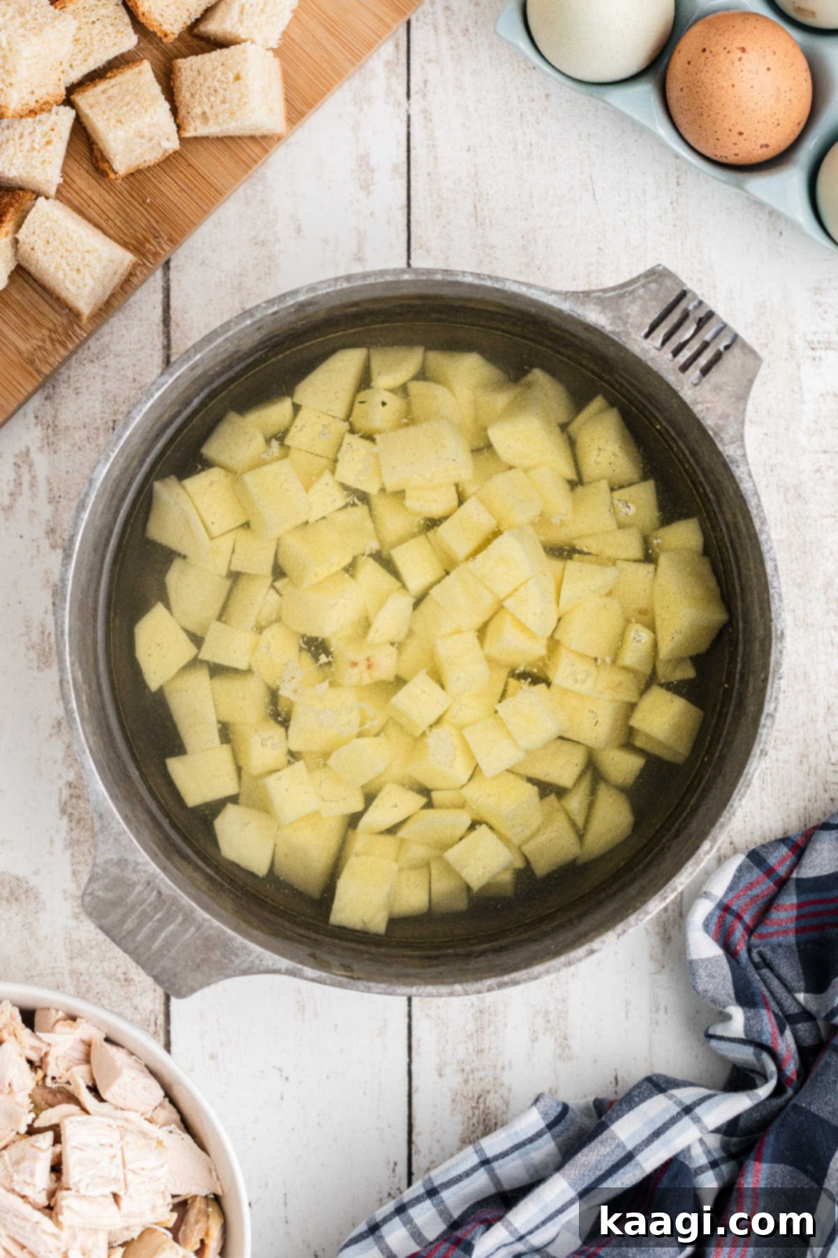 Small cubes of potatoes being cooked in a small pot.
