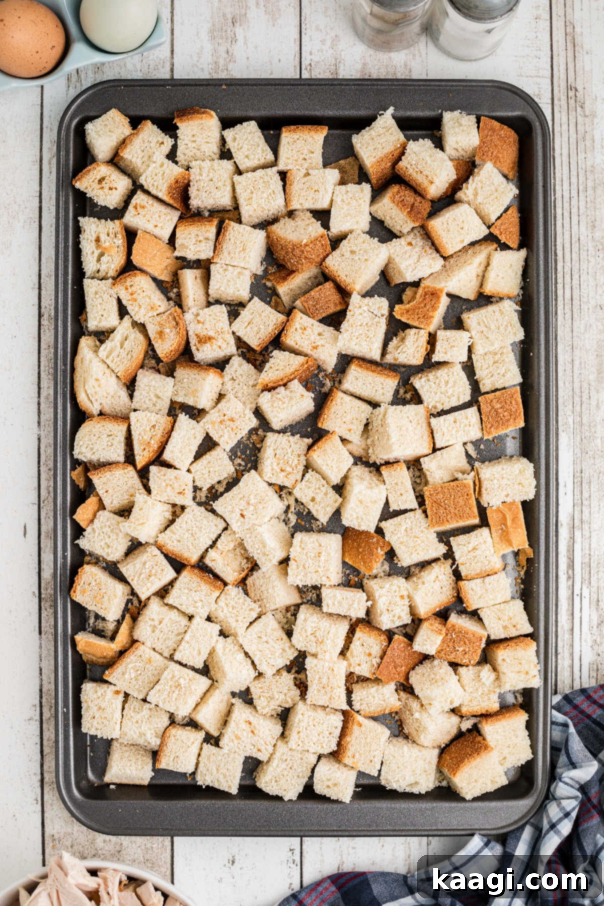 Cubes of bread laid out on a baking sheet.
