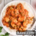 Overhead image of a plate of New Orleans shrimp creole with a fork on the side, ready for enjoyment.