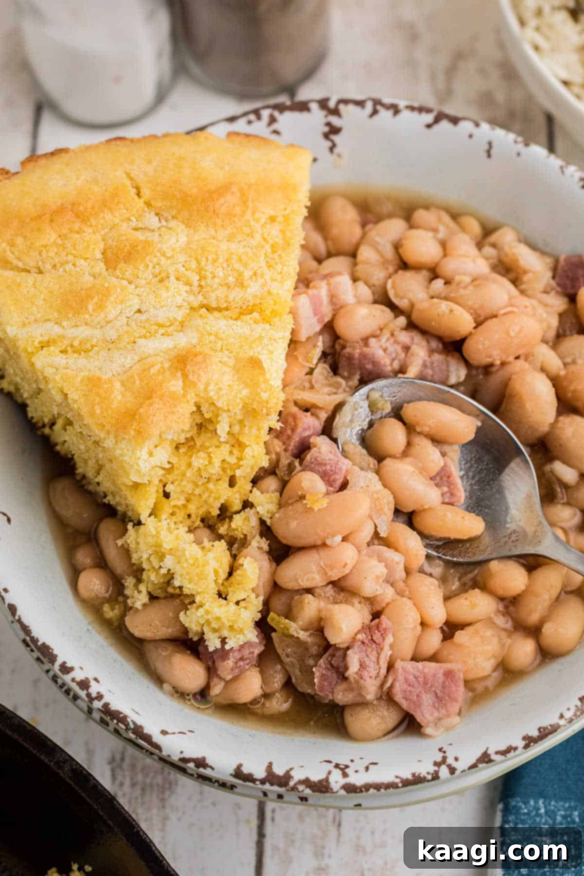 Close up of a bowl full of southern great northern beans with a slice of cornbread on the side.