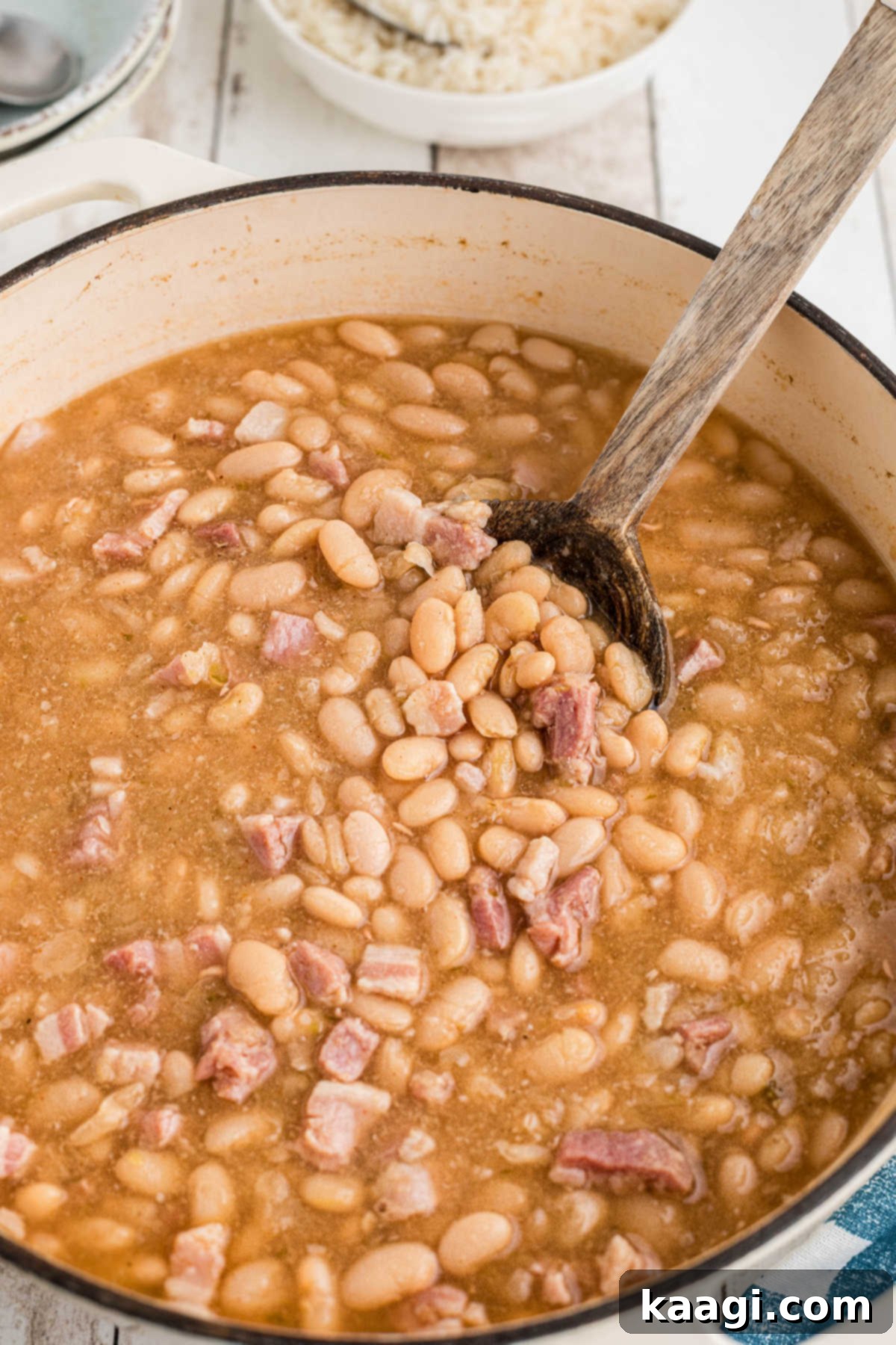 A large pot of Southern Great Northern Beans with a spoon digging in.