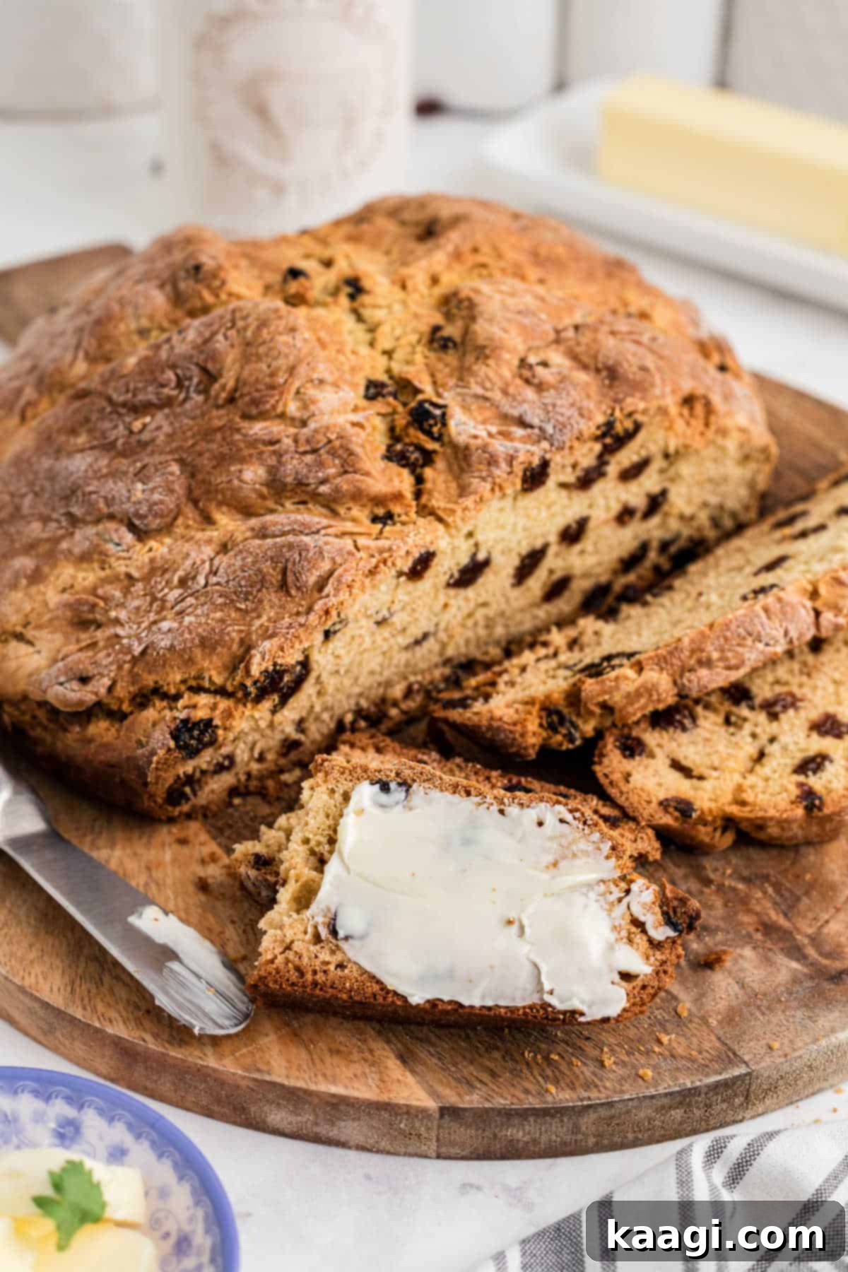 Easy Homemade Irish Soda Bread 14 Quick Irish Soda Bread on a wooden board with a slice buttered, ready to eat.