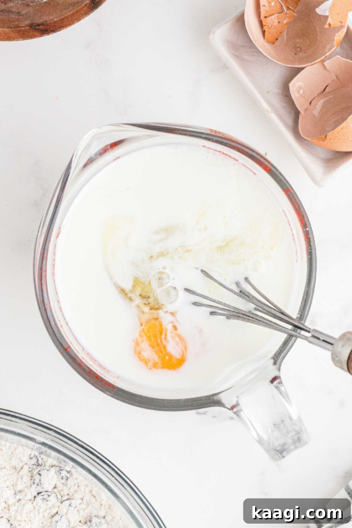 Easy Homemade Irish Soda Bread 7 Eggs being beaten into buttermilk in a measuring jug.