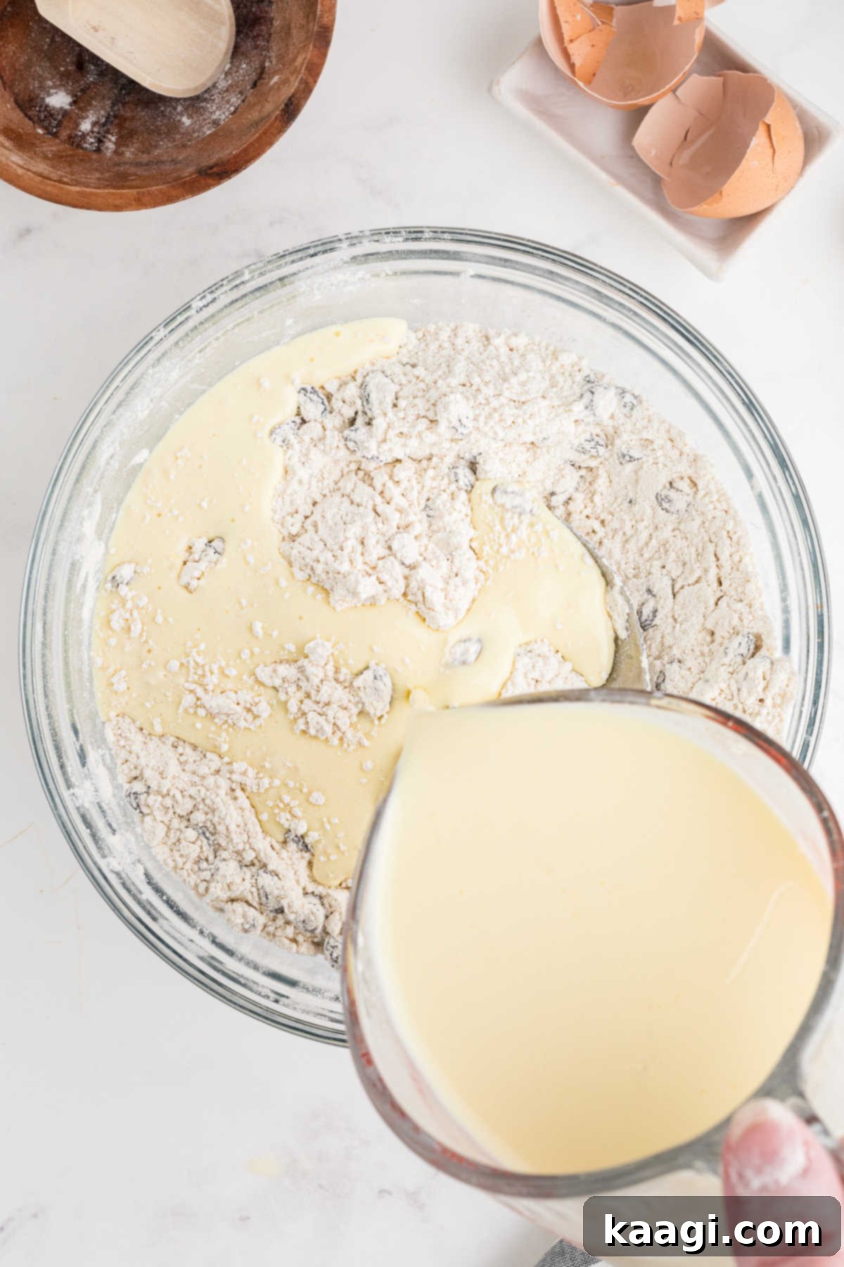 Easy Homemade Irish Soda Bread 8 Buttermilk egg mixture being poured into a flour mixture, forming a shaggy dough.