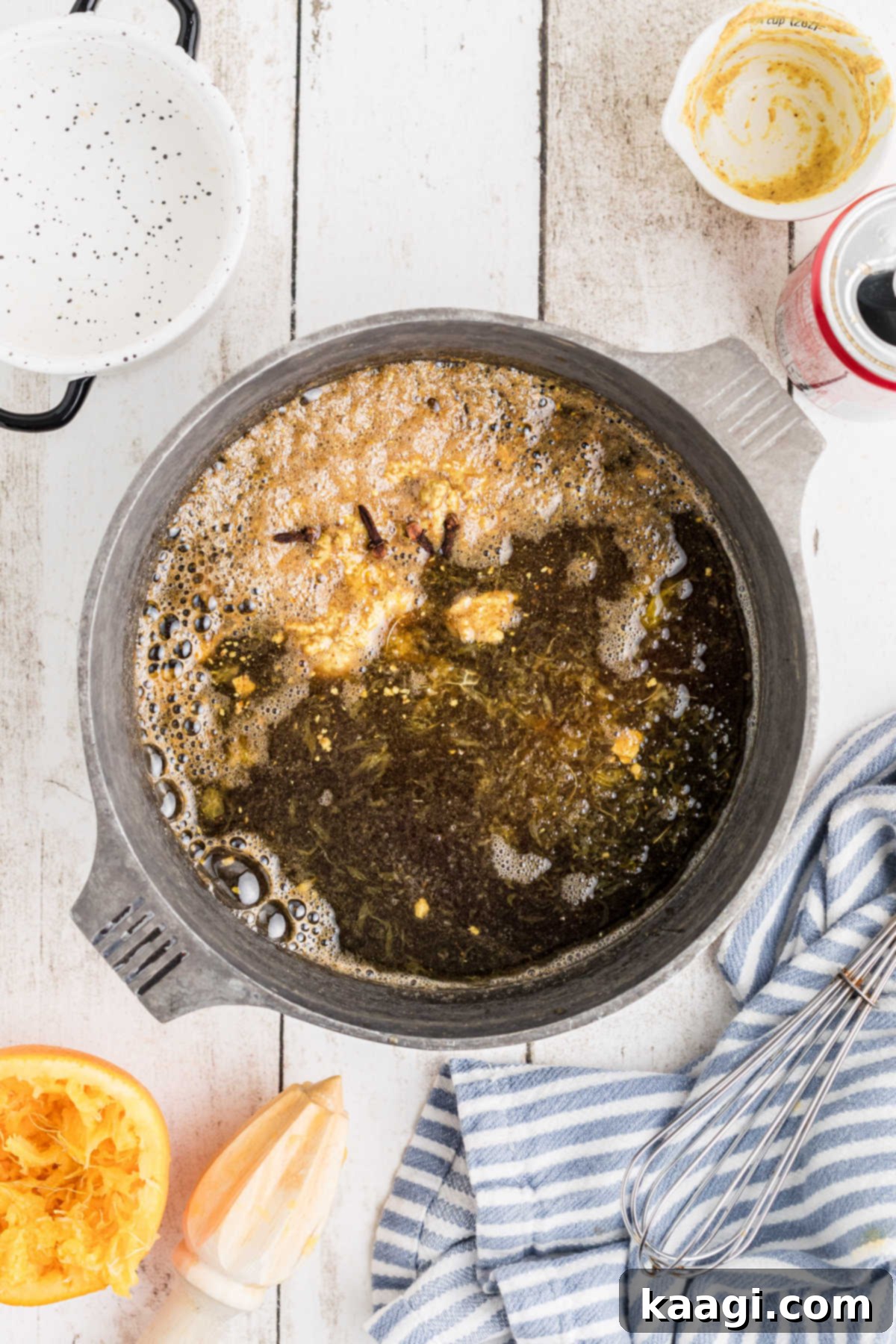 A small pot making a glaze for a baked ham, showing the liquids bubbling gently.