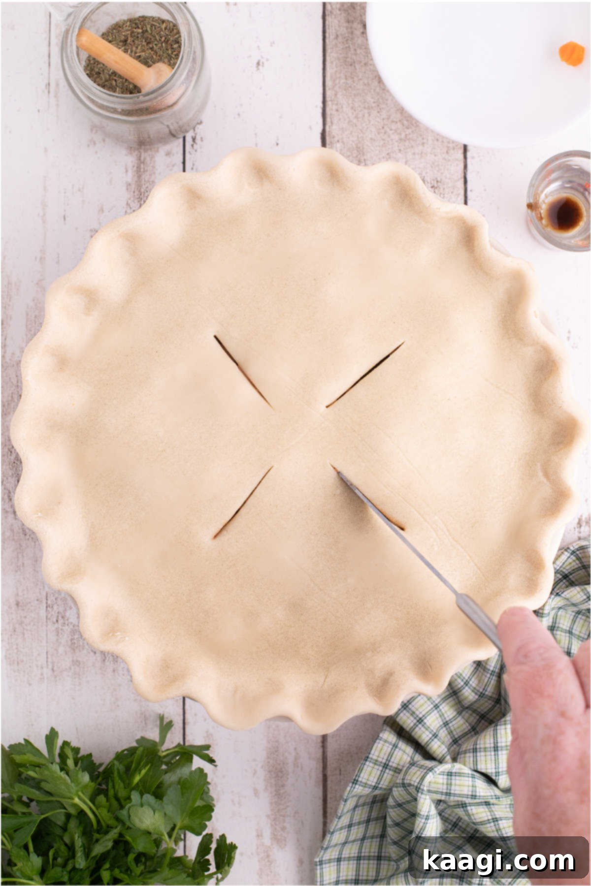 Slits being cut into a pie crust prior to baking.