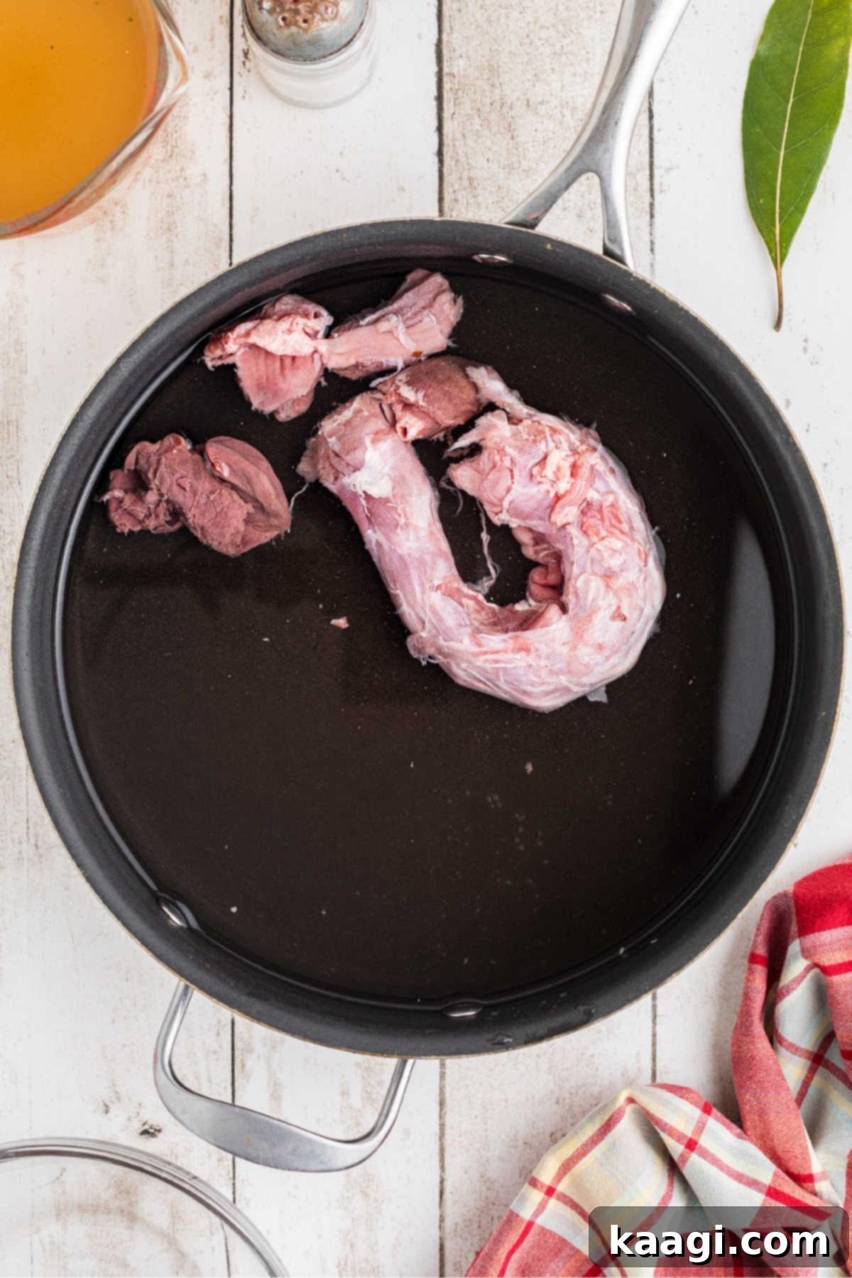 A pot of water cooking some turkey giblets and a turkey neck, slowly simmering to extract maximum flavor.
