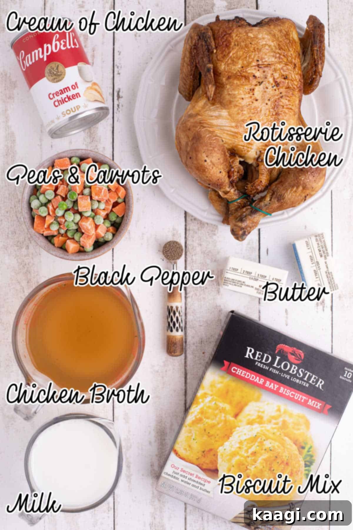 Overhead shot of ingredients needed to make a chicken cobbler recipe with red lobster biscuit mix, including butter, shredded chicken, frozen vegetables, biscuit mix, milk, cream of chicken soup, chicken broth, and black pepper.