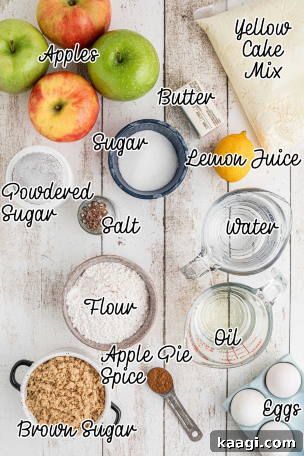 An overhead shot showcasing all the fresh ingredients laid out on a table, including yellow cake mix, apples, butter, sugar, and spices, ready for making apple pie cake.
