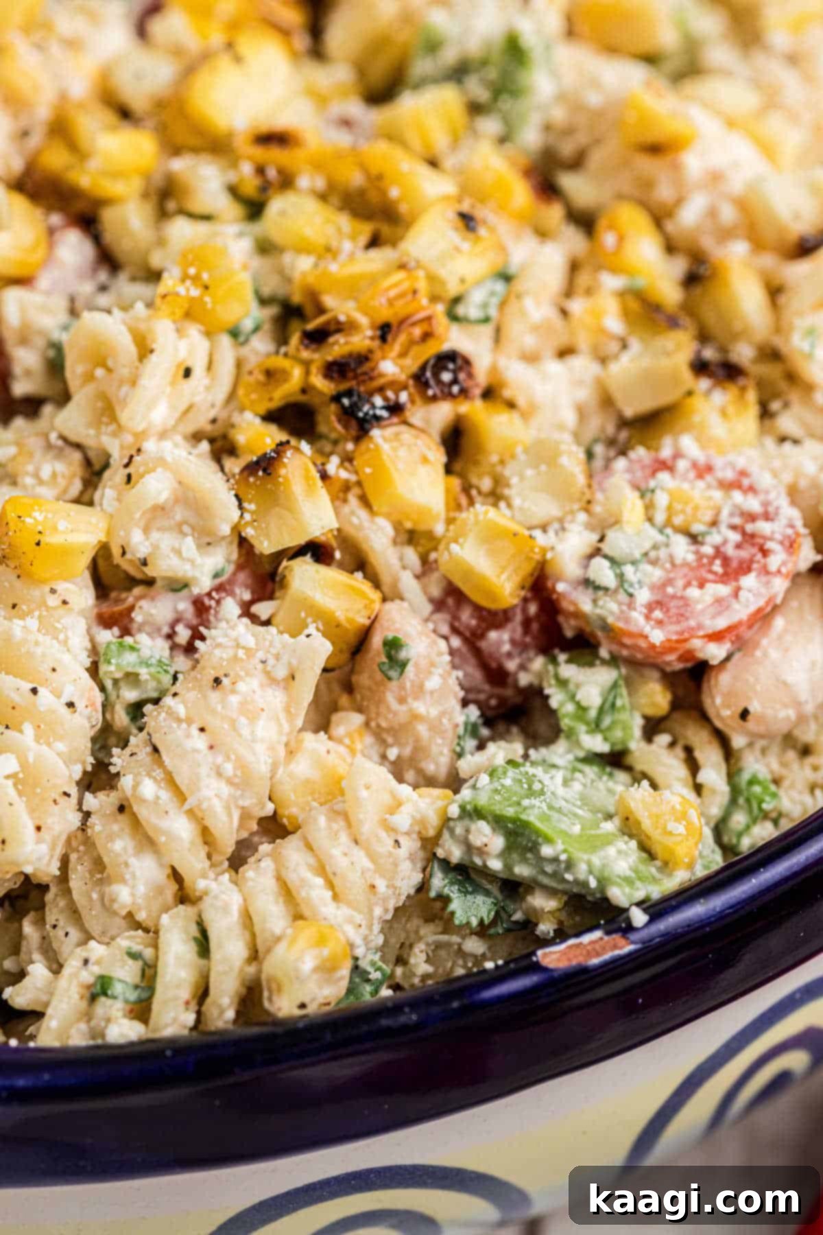 Close up shot of a bowl of Elotes pasta salad, highlighting its vibrant colors and textures.