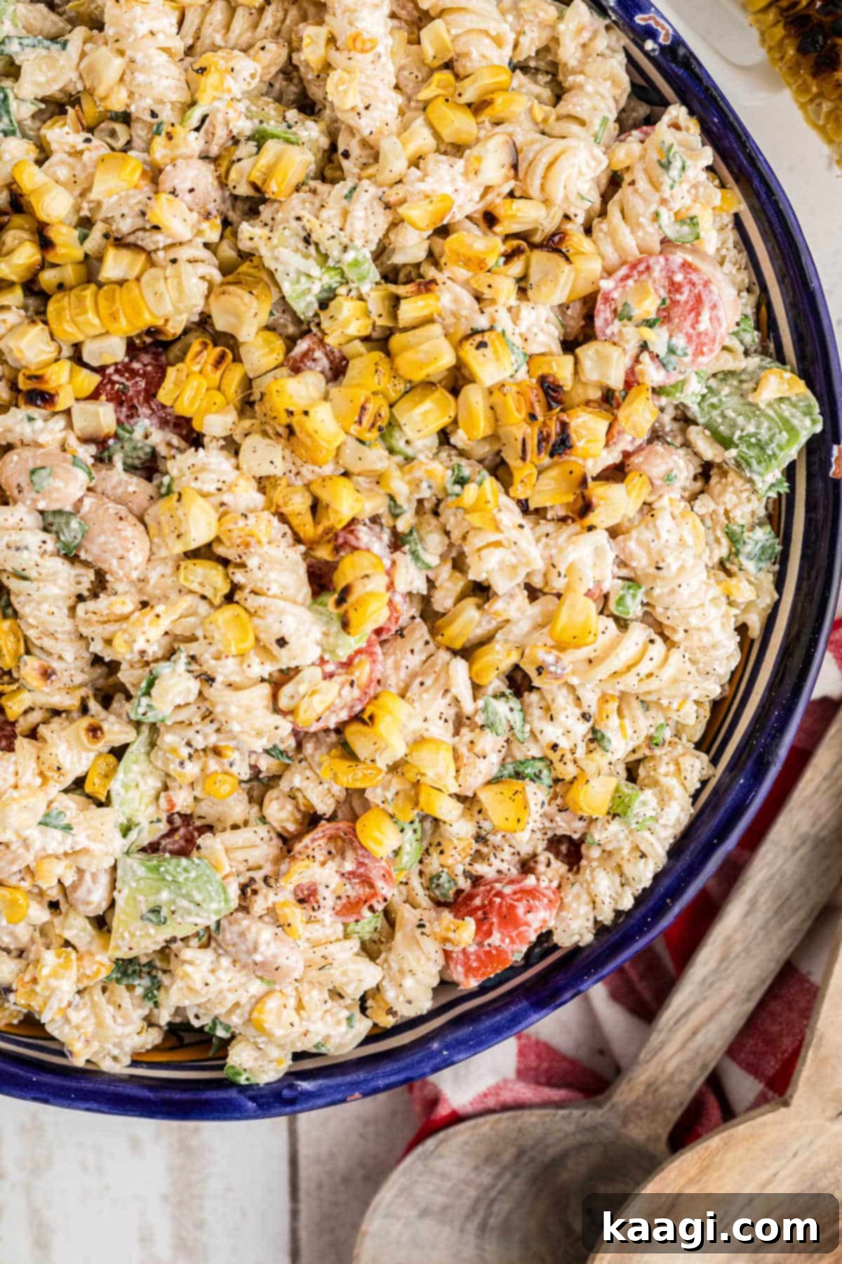 Close up overhead bowl of Elotes pasta salad, highlighting the creamy texture and vibrant ingredients.