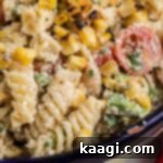 Very close up shot of a bowl of Elotes Pasta salad, cropped square.