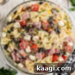 Italian Pasta Perfection 9 An overhead image of a bowl of Italian Pasta Salad, with seasoning grated on top.