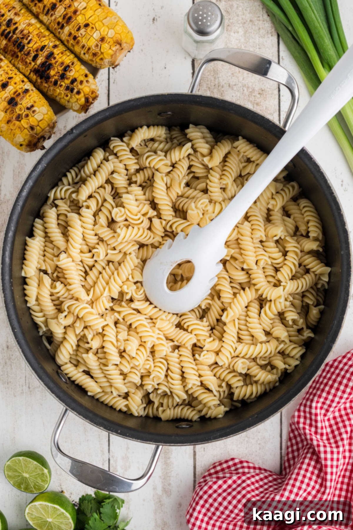 A large pot of perfectly cooked rotini pasta, ready to be drained and rinsed.