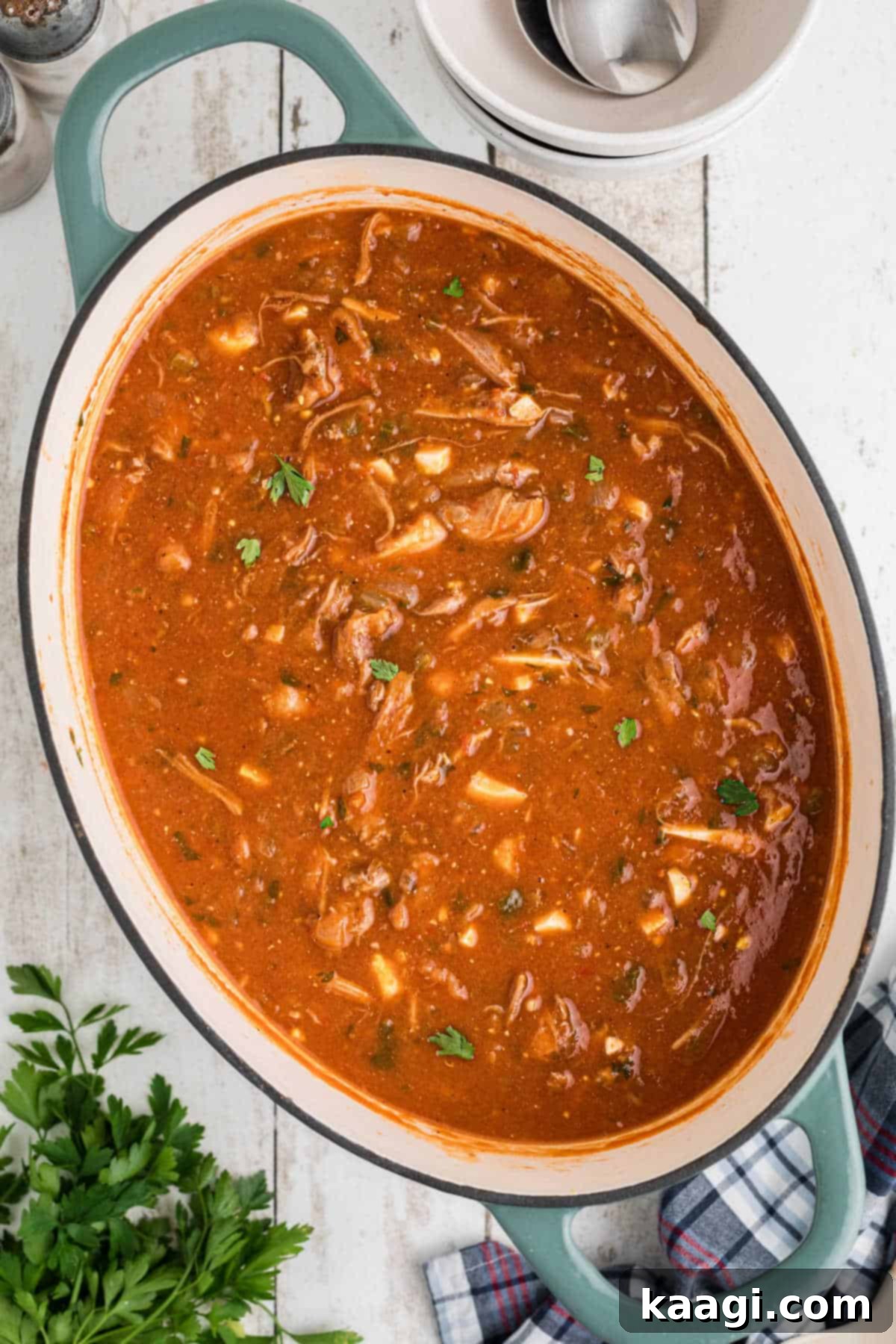 Overhead shot of a rustic oval-shaped pot filled with rich, dark Louisiana turtle soup, ready to be served.