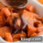 A dish full of yams with a treacle being poured over the top.