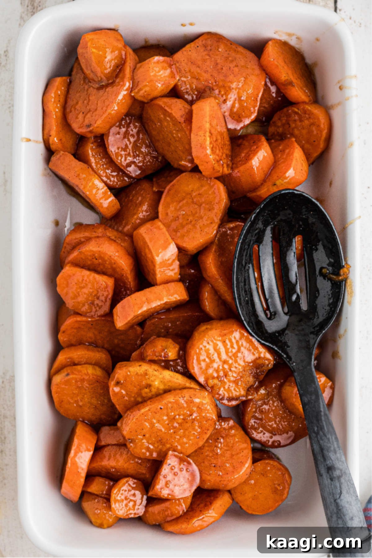 Candied yams added to a serving dish.