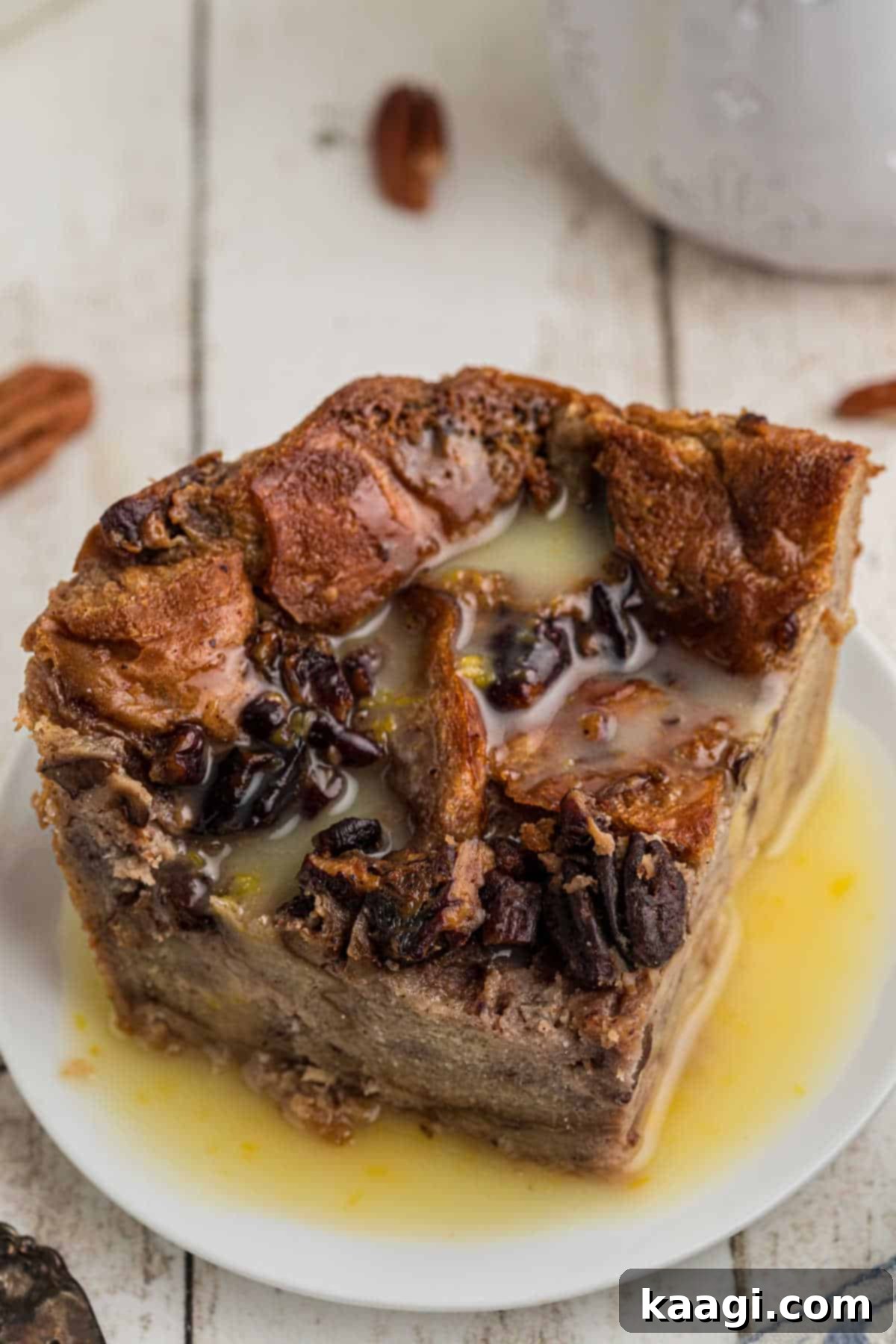 A plate of bread pudding with rum sauce generously poured over the top, ready to be enjoyed.
