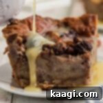 Rum sauce being poured over a slice of bread pudding.