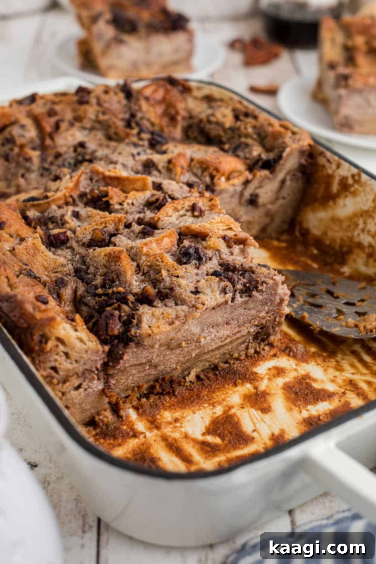 A dish of bread pudding, with some pieces removed, showcasing its warm, inviting texture.