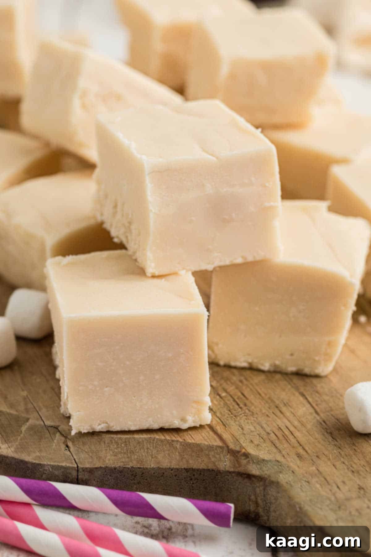 A pile of vanilla fudge on a wooden board, showcasing its smooth, creamy texture.