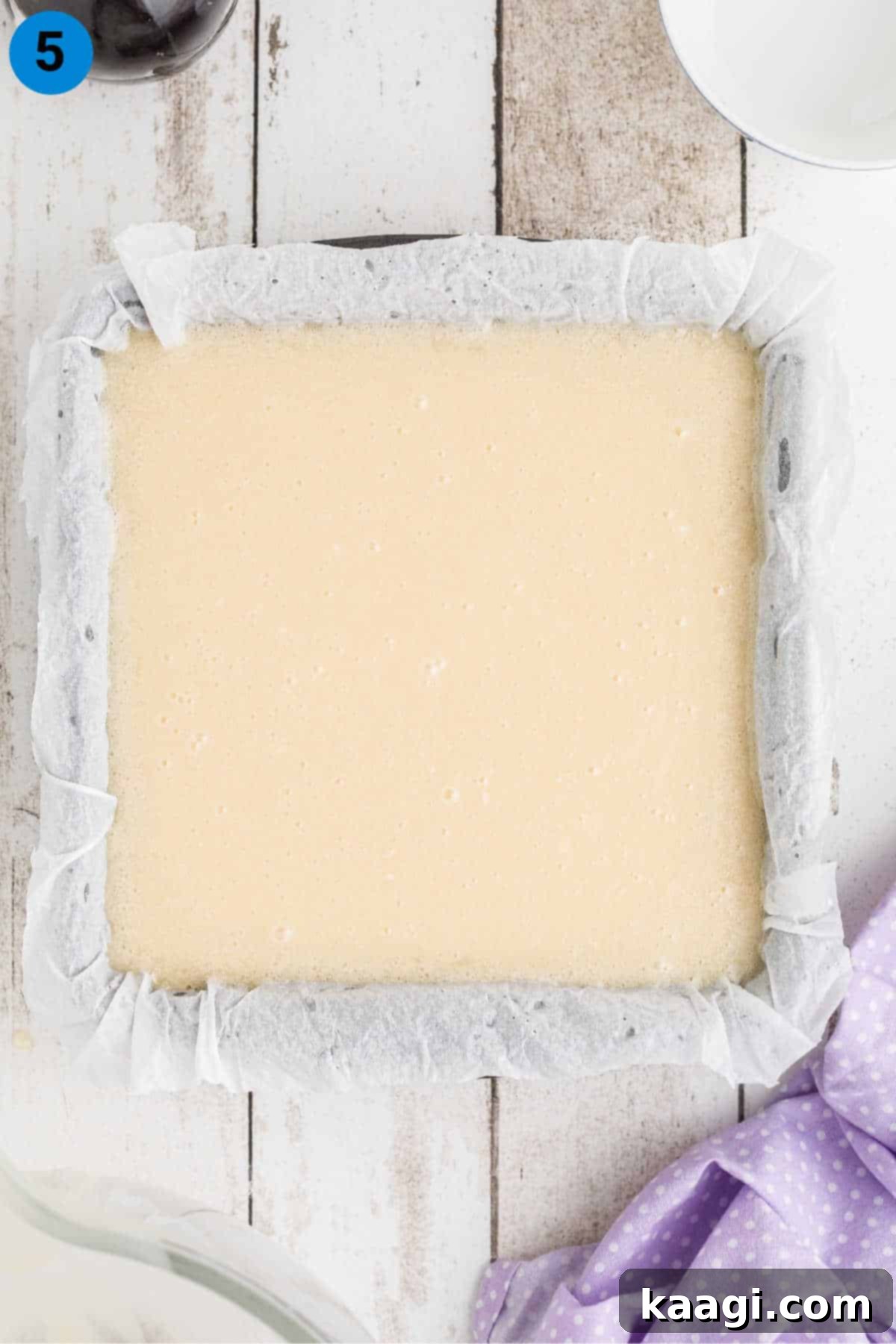 A square pan filled with unset vanilla fudge, smooth and ready for cooling.
